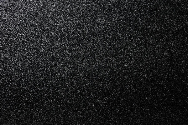 black shiny textured background,  close-up texture, representing the texture of car interior consoles and door panels.
