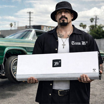 El Cholo Amp YouTube thumbnail. AI Generated image of a Cholo holding the Amp in front of a green and gold low rider car. 